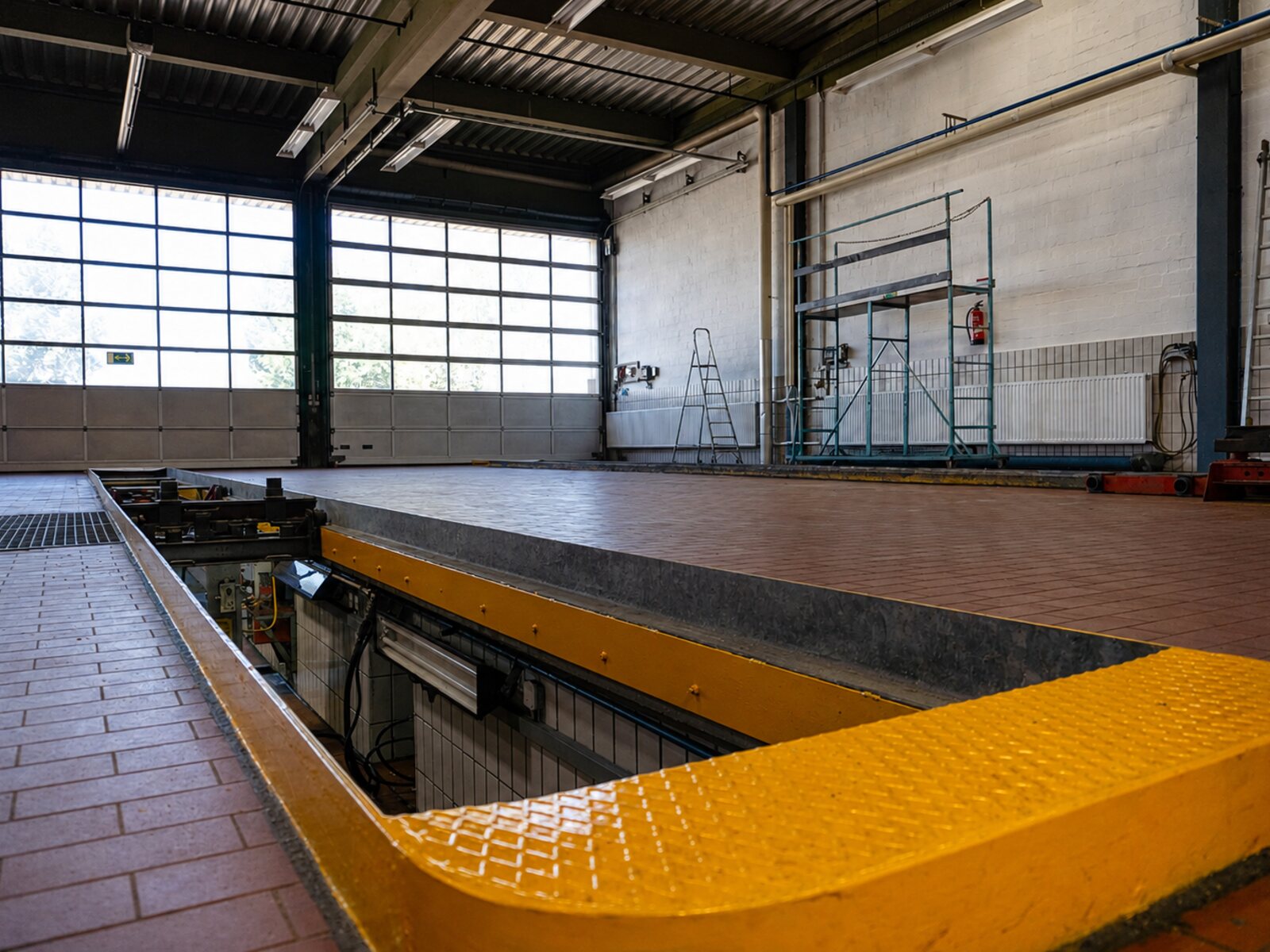 Eine der zwei Werkstattgruben in der Gewerbehalle mit gelber Sicherheitskante und technischer Ausstattung